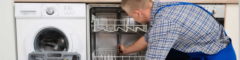 Appliance repair technician inspecting a washing machine